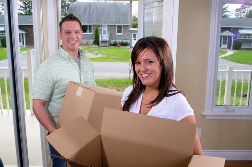 Movers carrying items through a staircase in a Barnet flat building